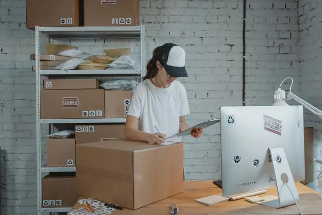 Worker packing shipment boxes at a desk