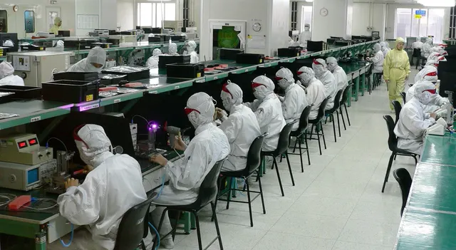 Workers checking boards on an electronics production line
